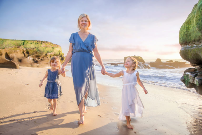 Mother in blue dress walking at Windandsea with her two little girls