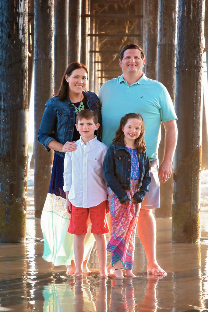 Family posing underneath the Oceanside Pier