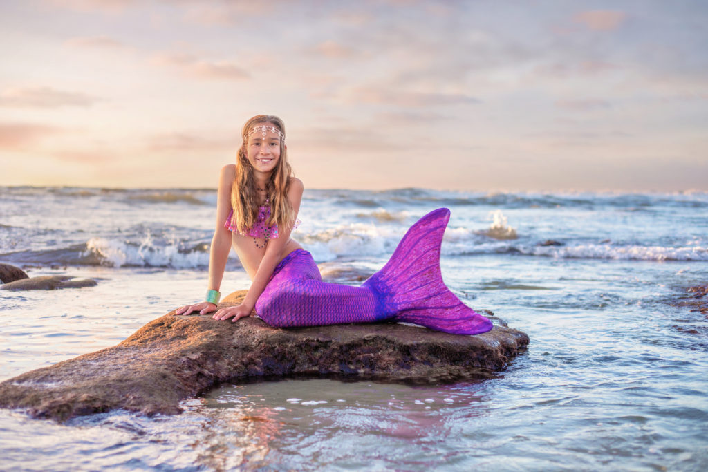 San Diego Mermaid on a rock with a purple tail