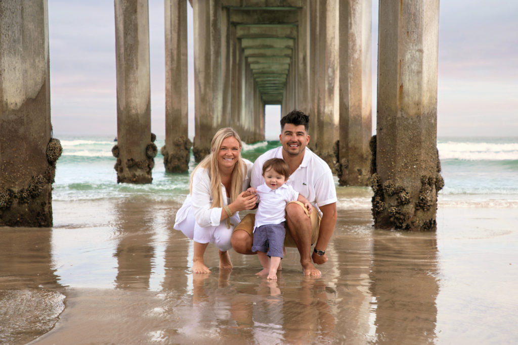 Family posing under Scripps Pier