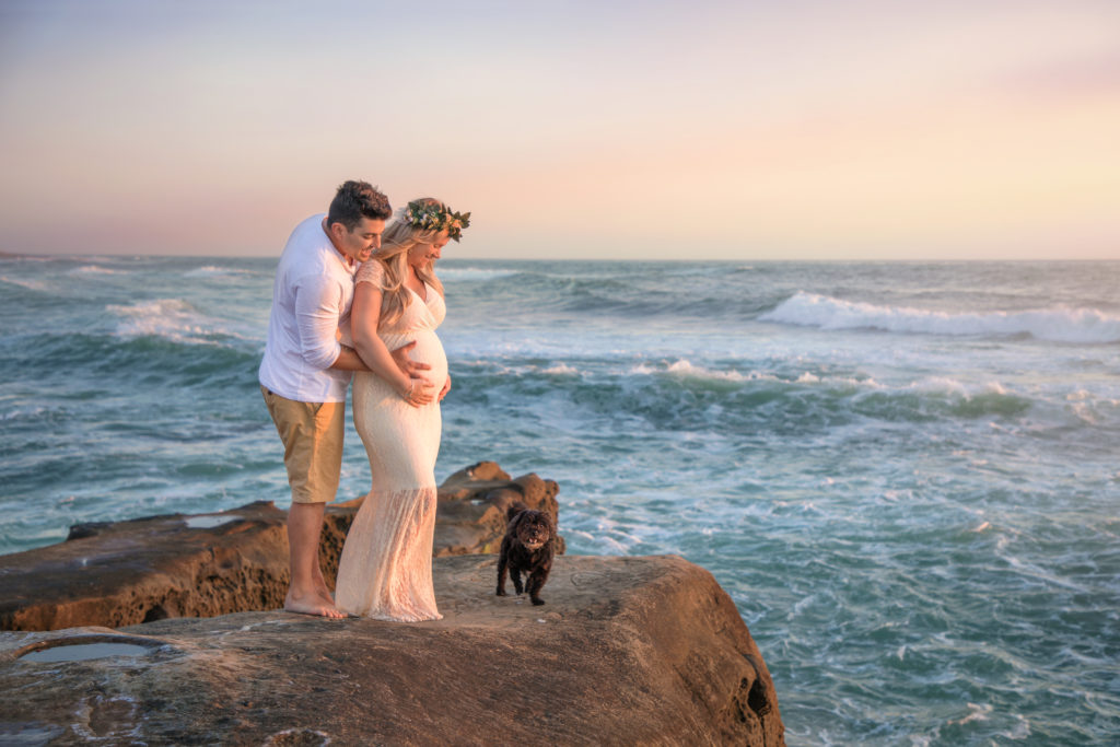 Beach maternity photo shoot with dog at sunset.